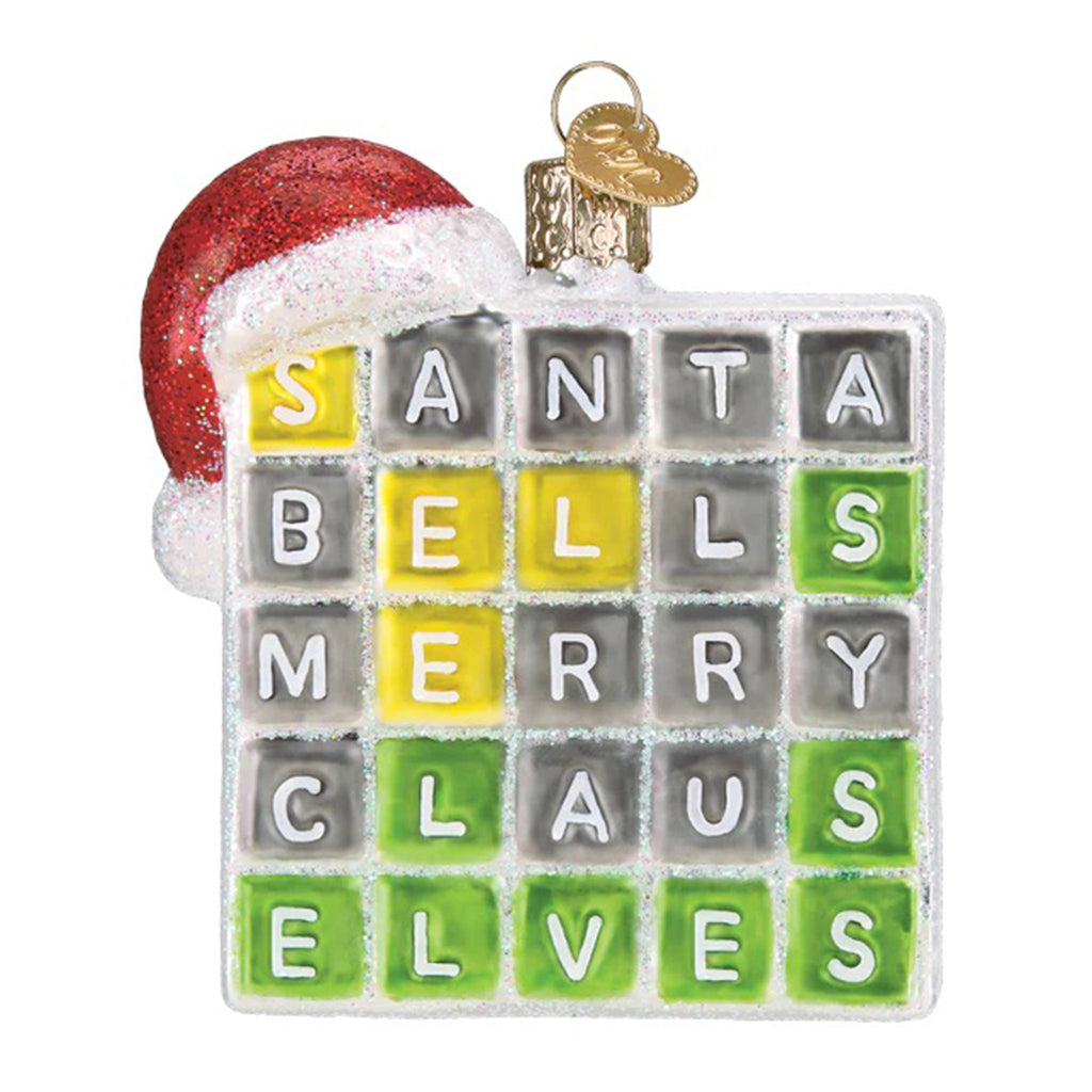 Glass holiday tree ornament with a word game square that looks like wordle with "elves" as the solution and a santa hat hanging on the top left corner.