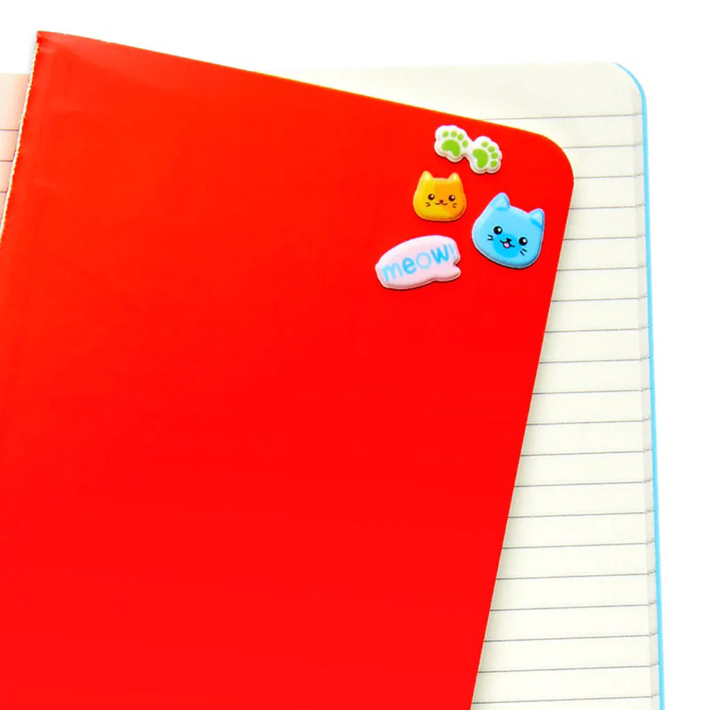small cat faces, paw print and "meow!" puffy stickers on cover of a red notebook with lined pages