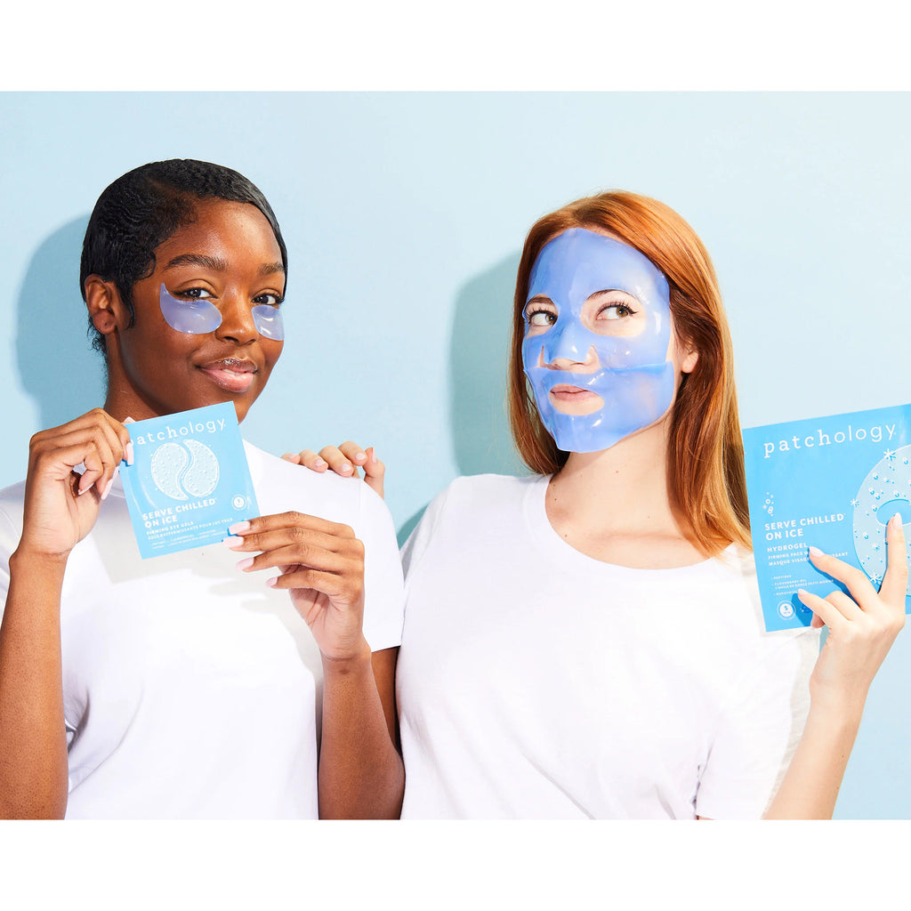 2 women wearing Patchology Serve Chilled on Ice, one is wearing the eye gels and holding the packaging, the other is wearing the face mask and holding the packaging.