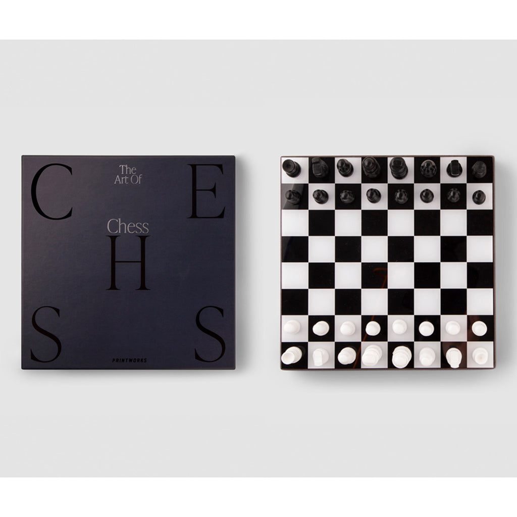 printworks the art of chess black and white chess board with wood pieces and top of the black box packaging.