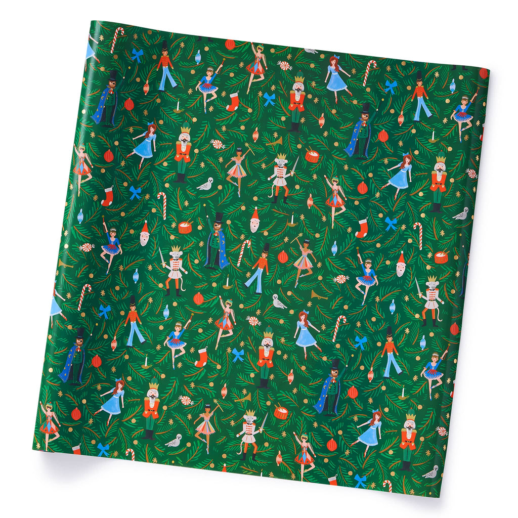 Wrapping paper printed with characters from the Nutcracker ballet on a dark green backdrop with evergreen branches, on roll.