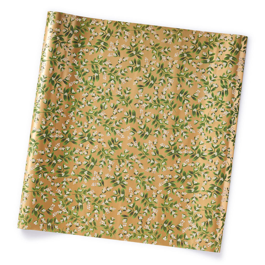 Wrapping paper printed with sprigs of green and white mistletoe on a metallic gold background, on roll.