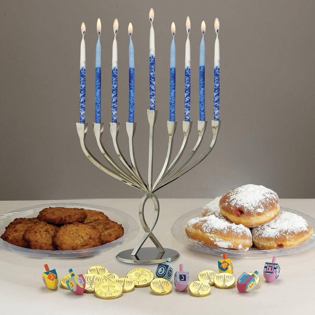 Modern aluminum menorah with a chrome finish with jelly doughnuts, latkes, gelt, dreidels and blue and white candles that are lit.