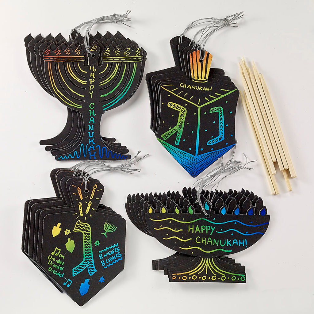 Chanukah scratch art dreidel and menorah cards with silver cord loops for hanging and wood scratch tools. The top cards have rainbow designs etched on them. 