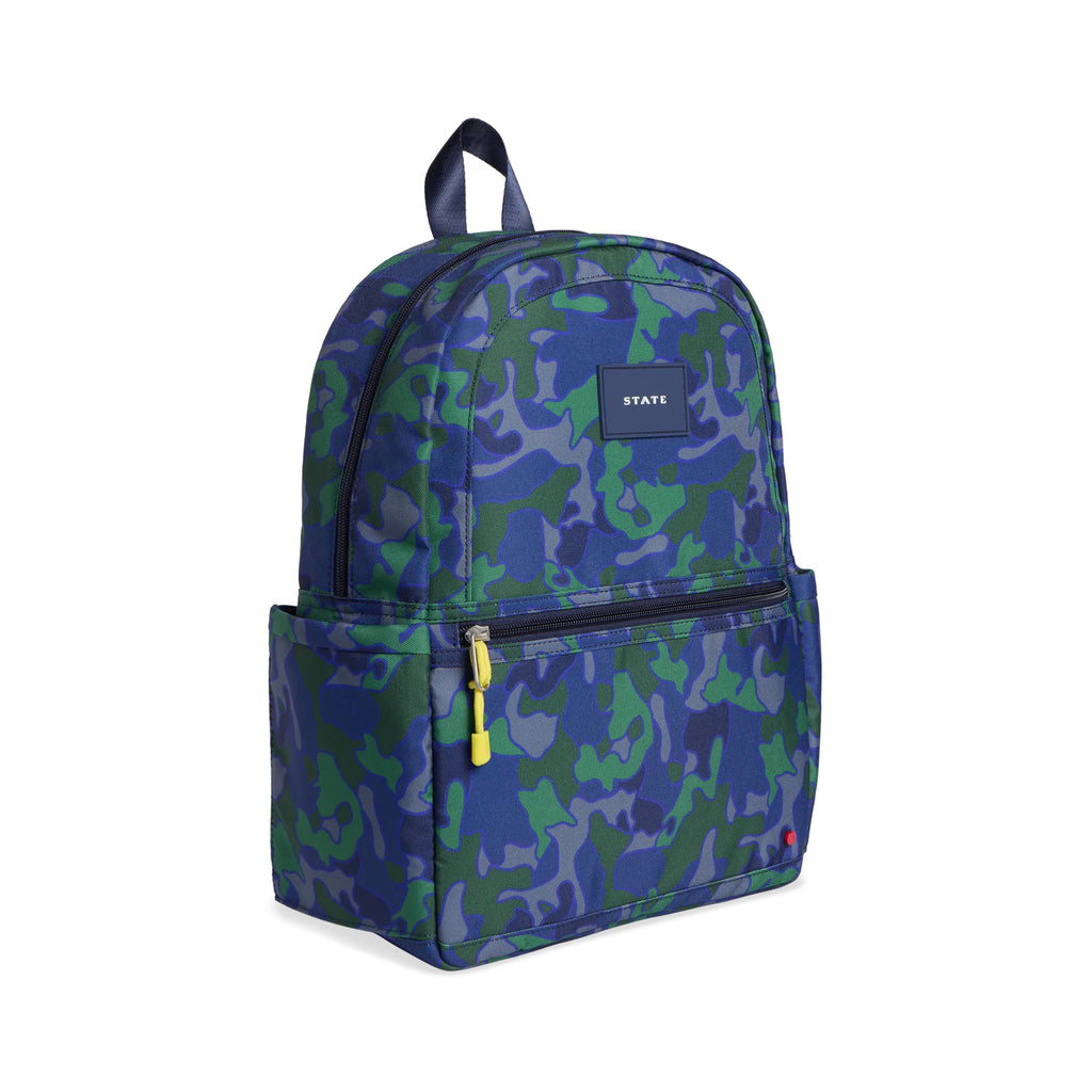 kane small kids backpack with a blue and green camouflage print front and side angle view with yellow zipper pulls, shoulder straps and a navy top locker loop