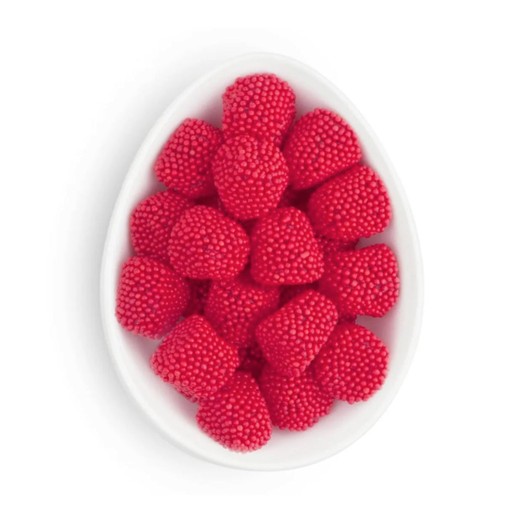 Raspberry flavored gummy candy shaped like raspberries and covered in red non-pareils in white oval dish.