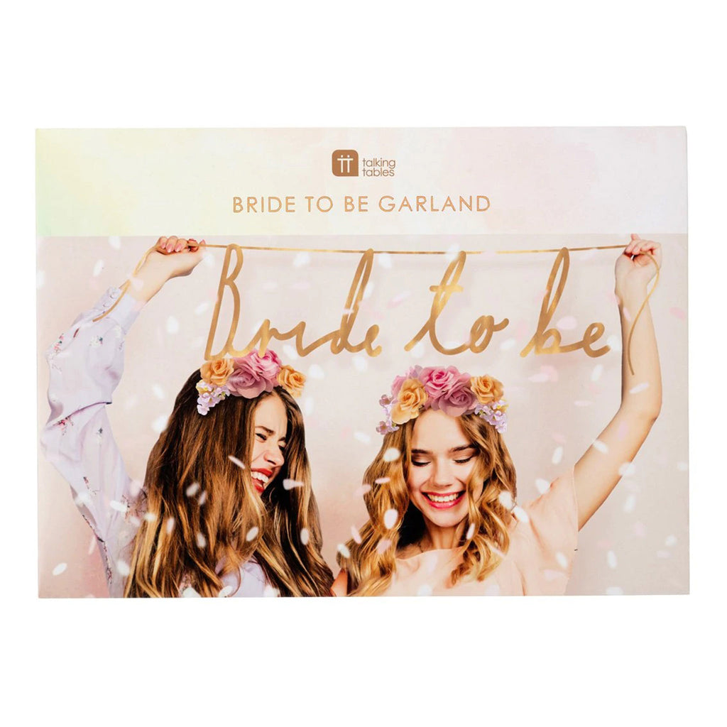 talking tables rose gold "bride to be" garland party decoration in box front with photo of 2 women with floral headbands holding the banner over their heads
