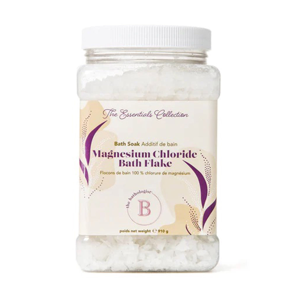The Bathologist Magnesium Chloride Flake Bath Soak in clear container with white screw-on-lid and tan label.