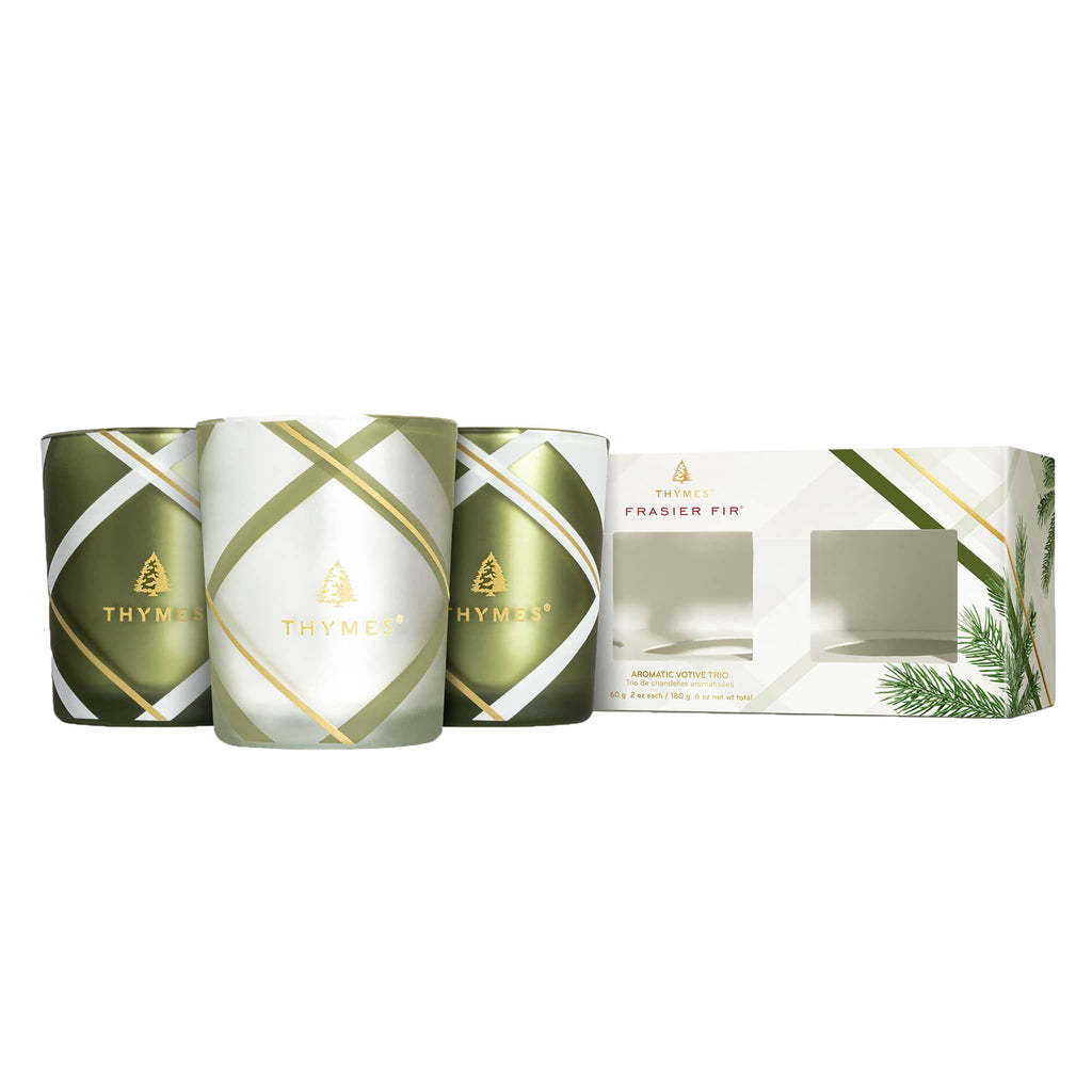 Set of 3 frasier fir scented votive candles in glass vessels with green, gold and white plaid print in 2 designs, matching box is beside the candles.