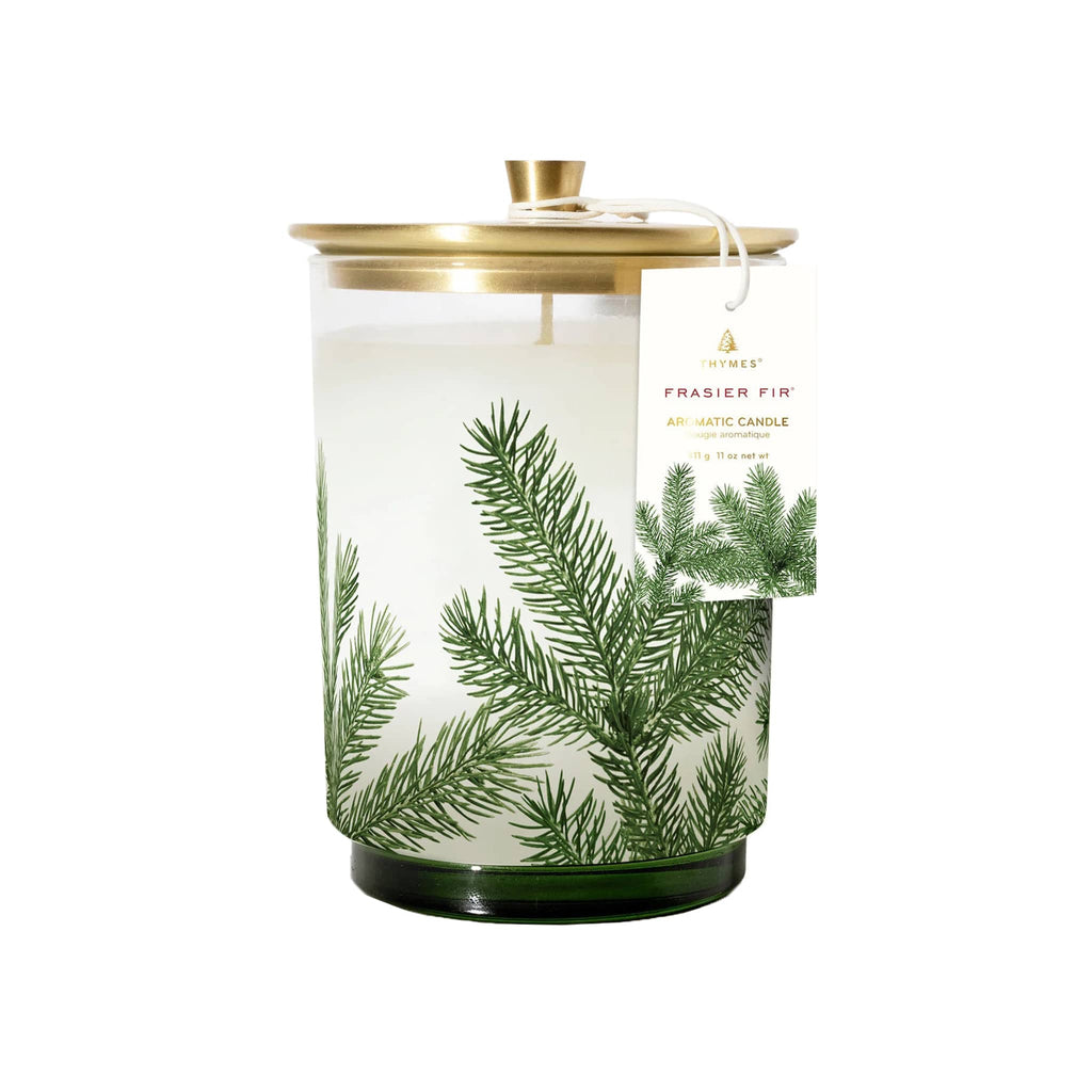 Tapered clear glass vessel with green base and a green pine needle design with a brushed gold lid on top.
