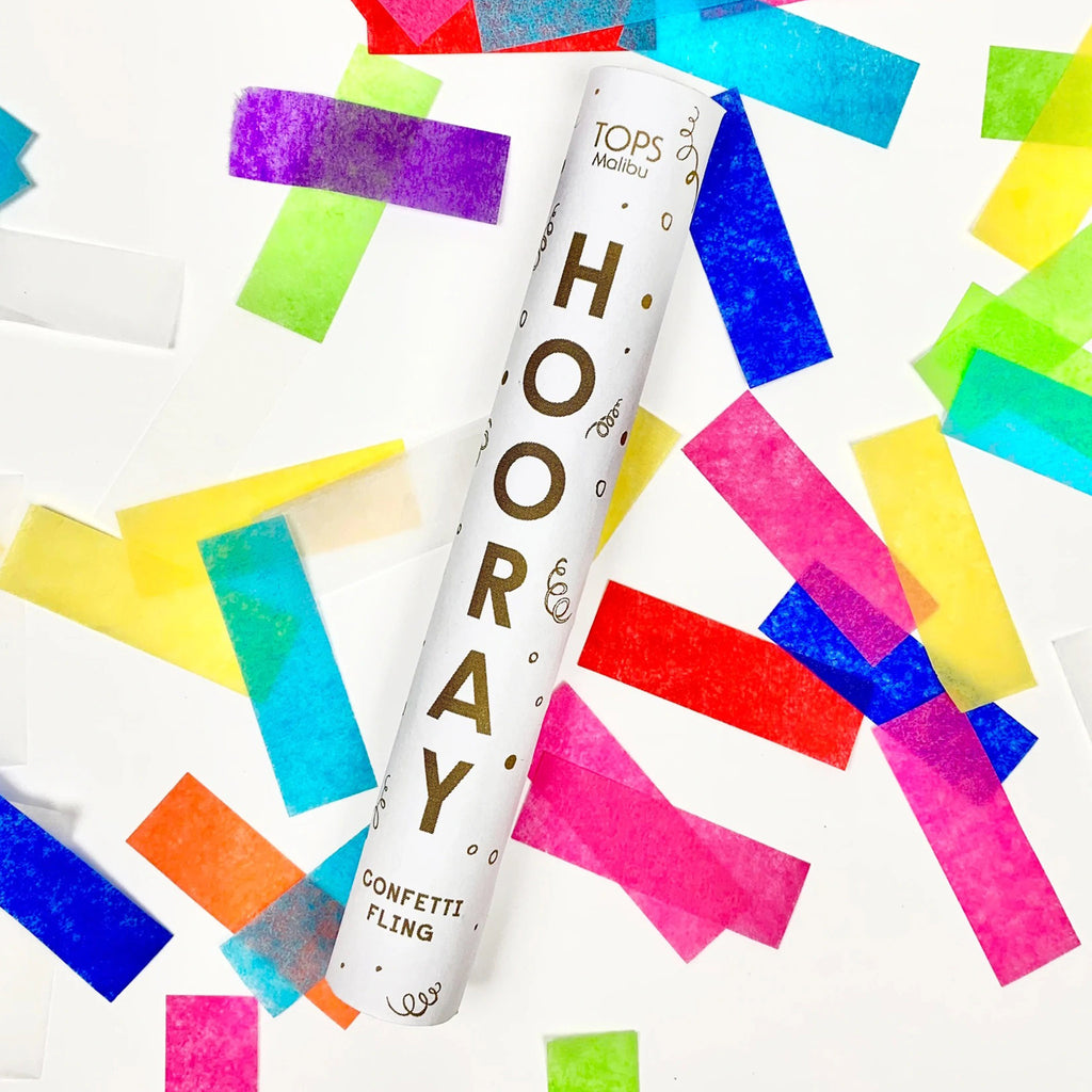 tops malibu confetti fling white tube with "hooray" on the front in gold foil letters with large, colorful confetti pieces scattered all around