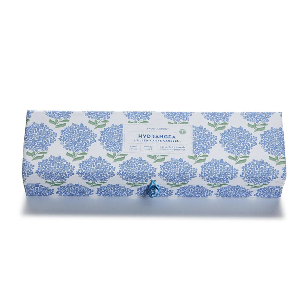 Two's Company Hydrangea Votive Candle Set in box packaging covered with a repeating illustration of a blue hydrangea bloom with green leaves.