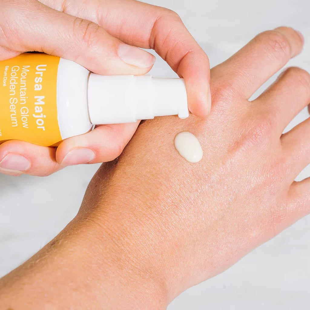 ursa major mountain glow golden serum being dispensed on the back of a hand to show texture.