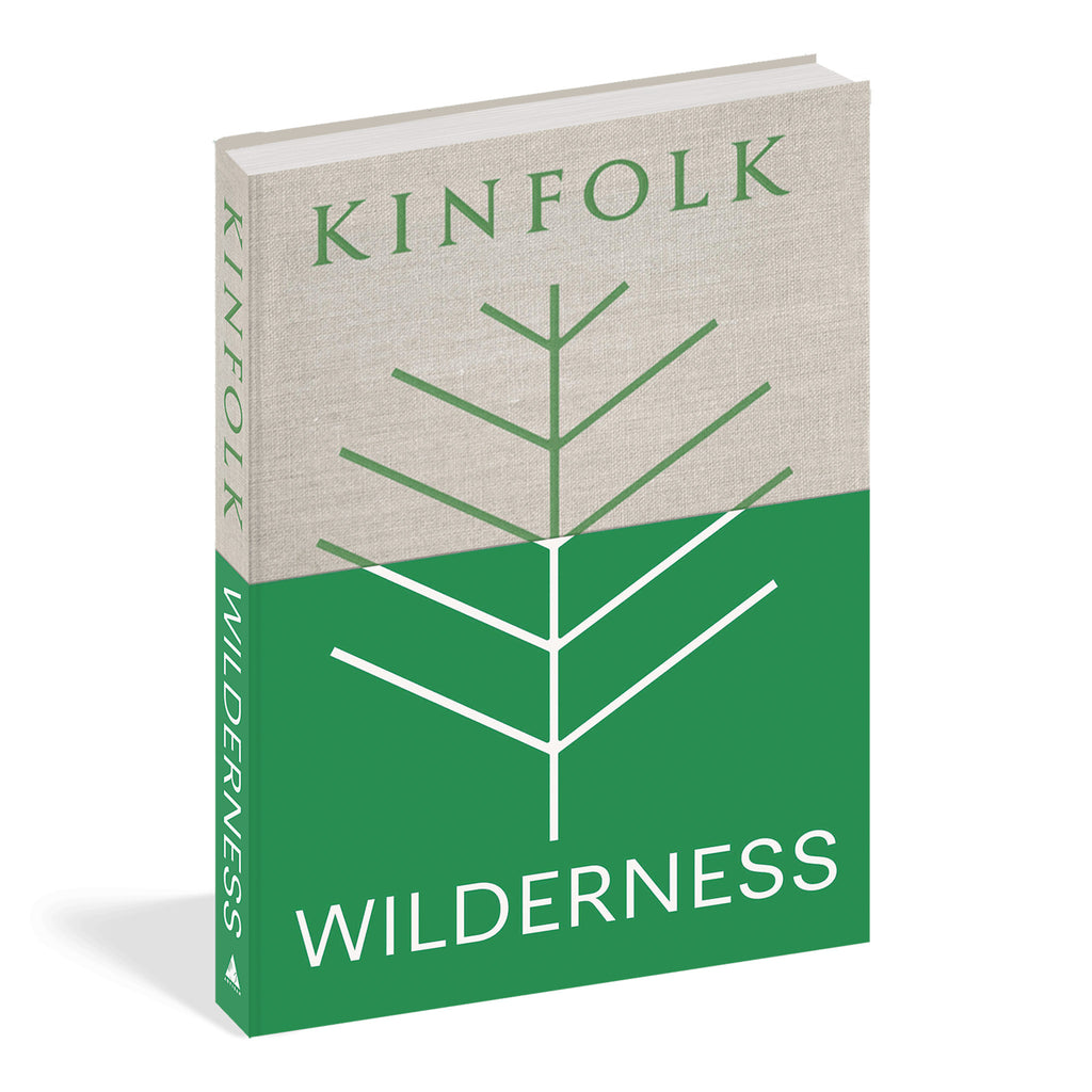 Front cover of Kinfolk Wilderness hardcover book by John Burns. The bottom half is green with bottom of stick tree illustration, the top half is tan with green lettering and top of stick tree.